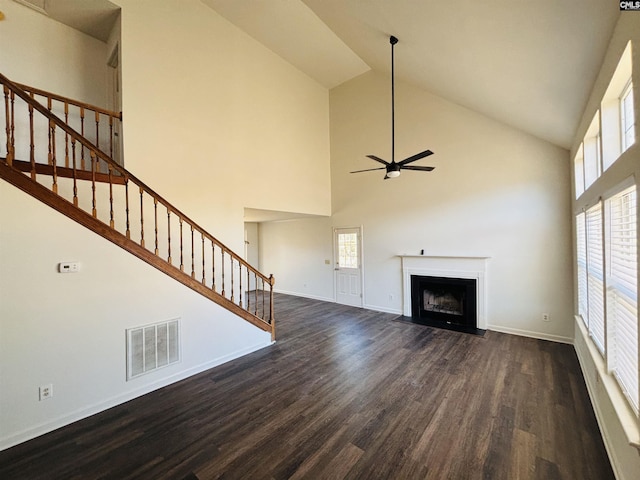 unfurnished living room with dark hardwood / wood-style flooring, high vaulted ceiling, and ceiling fan