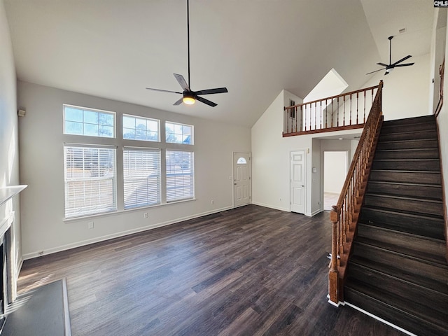 unfurnished living room with dark hardwood / wood-style flooring, high vaulted ceiling, and ceiling fan