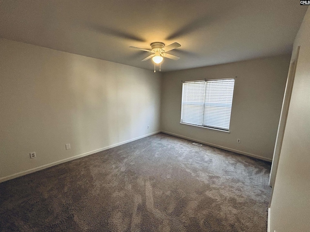 unfurnished room with ceiling fan and dark colored carpet