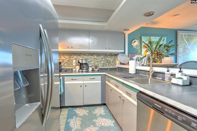 kitchen with backsplash, sink, and appliances with stainless steel finishes