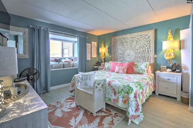 bedroom featuring light hardwood / wood-style floors and a textured ceiling