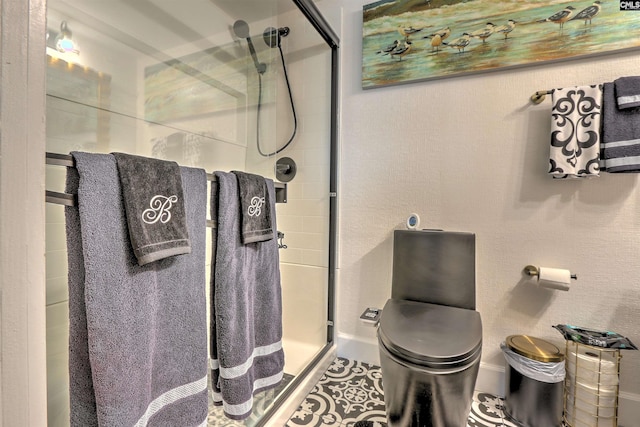 bathroom with an enclosed shower, tile patterned floors, and toilet