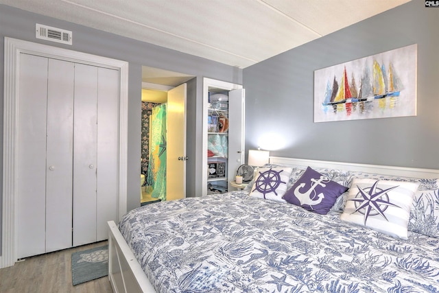 bedroom with light hardwood / wood-style floors and a closet