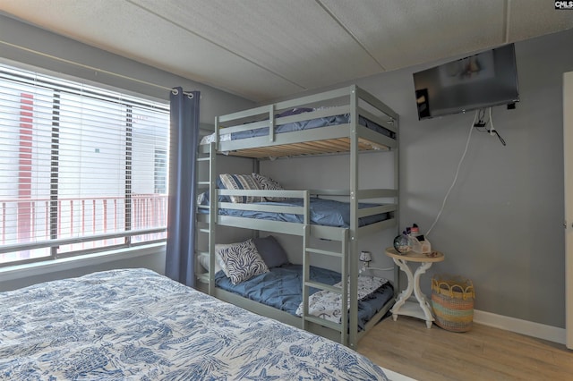 bedroom with multiple windows, wood-type flooring, and a textured ceiling