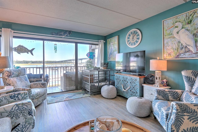 living room with a water view, hardwood / wood-style floors, and a textured ceiling