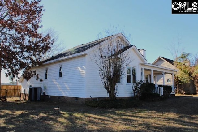 view of property exterior featuring cooling unit, a porch, and a yard