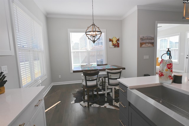 dining area with crown molding, a healthy amount of sunlight, and dark hardwood / wood-style flooring