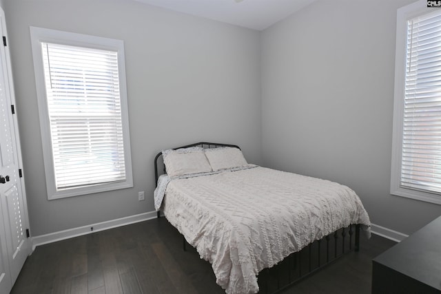 bedroom with dark hardwood / wood-style floors and a closet