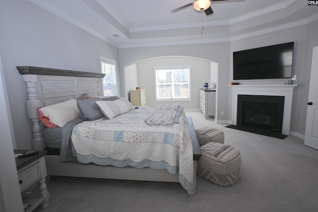 bedroom with ornamental molding, a raised ceiling, ceiling fan, and carpet flooring