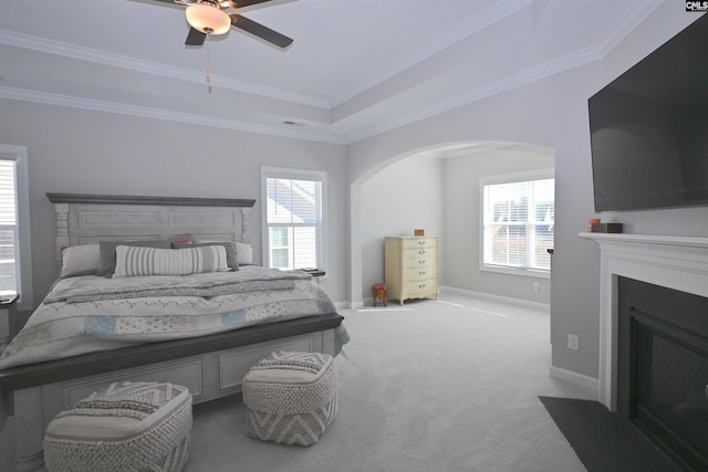 bedroom with a raised ceiling, ornamental molding, carpet floors, and ceiling fan