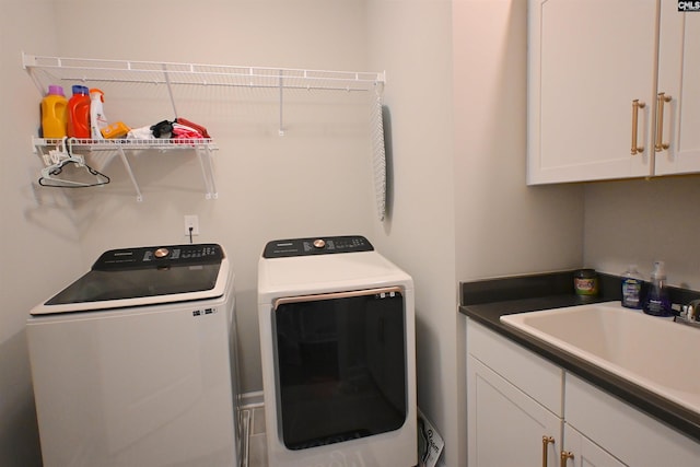 laundry room featuring cabinets, sink, and washer and dryer