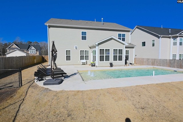 rear view of house with pool water feature, a fenced in pool, and a patio area