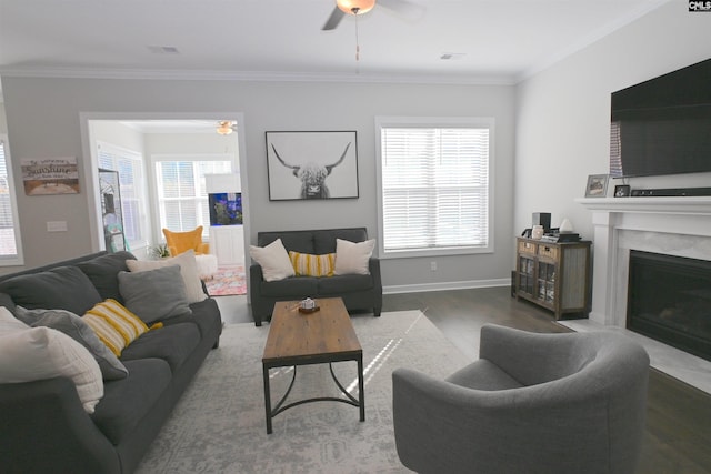 living room with ceiling fan, ornamental molding, a high end fireplace, and wood-type flooring