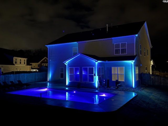 view of front facade with a fenced in pool and a patio