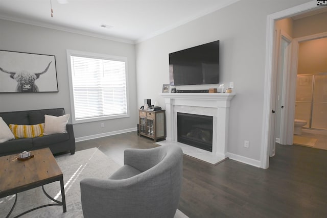 living room featuring crown molding, a fireplace, and dark hardwood / wood-style floors