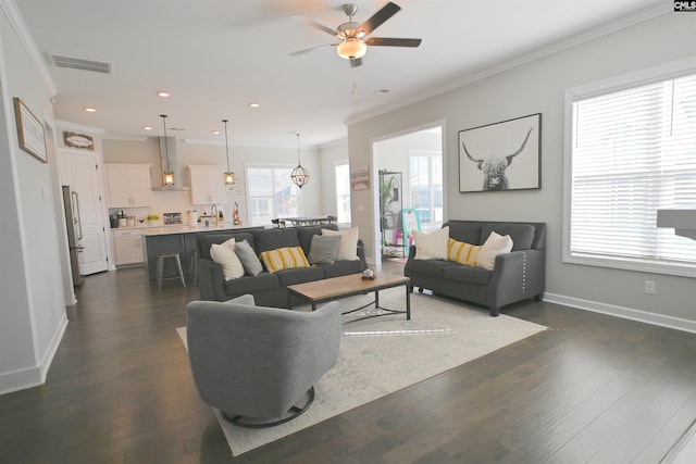 living room with ornamental molding, dark wood-type flooring, sink, and ceiling fan