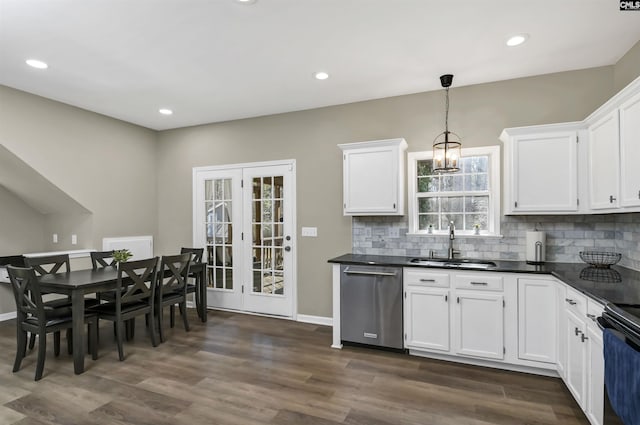 kitchen featuring hanging light fixtures, sink, stainless steel dishwasher, and white cabinets