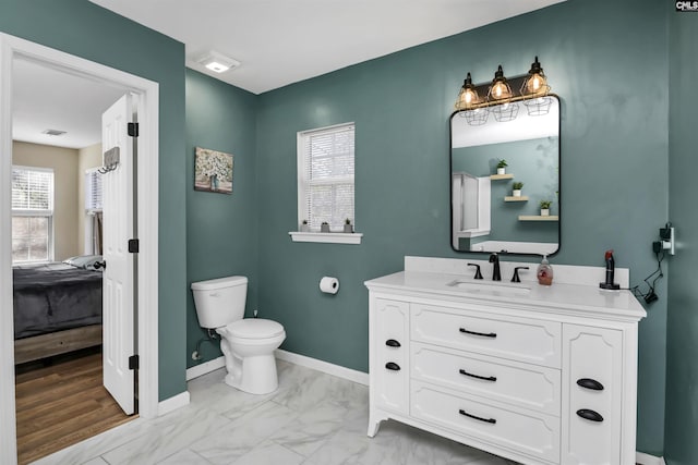 bathroom featuring vanity, plenty of natural light, and toilet