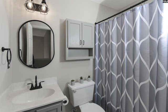 bathroom with vanity, curtained shower, a textured ceiling, and toilet