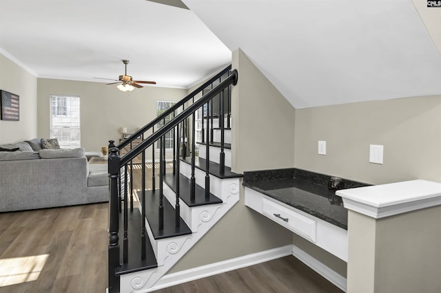 stairs with lofted ceiling, hardwood / wood-style flooring, ornamental molding, and ceiling fan