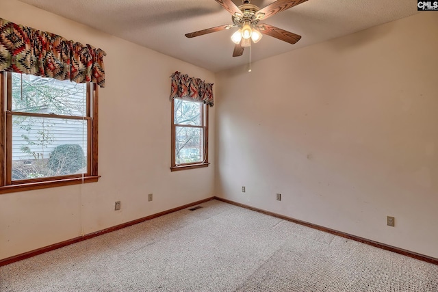 carpeted spare room with ceiling fan and a textured ceiling