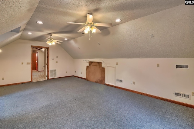 additional living space featuring ceiling fan, vaulted ceiling, a textured ceiling, and carpet