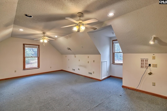 additional living space with lofted ceiling, ceiling fan, carpet floors, and a textured ceiling