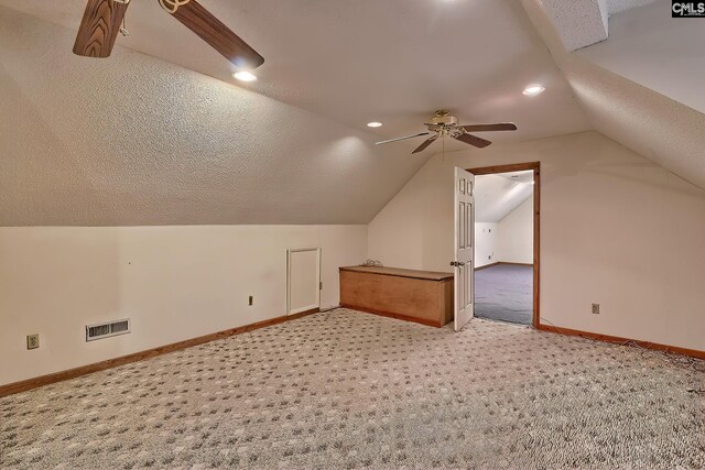 additional living space with ceiling fan, carpet flooring, vaulted ceiling, and a textured ceiling