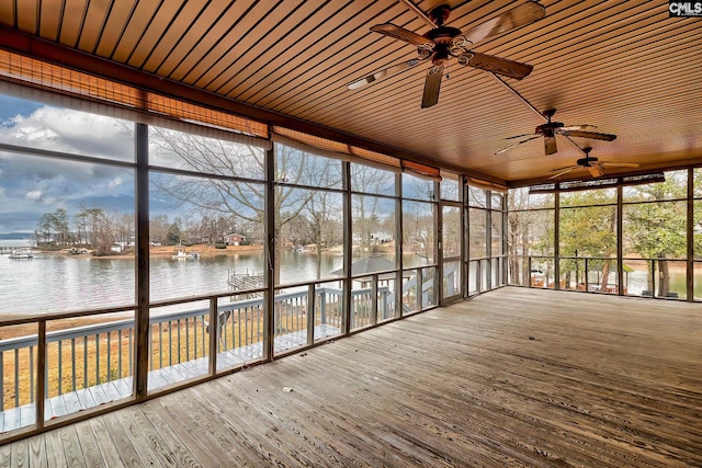 unfurnished sunroom featuring a water view and ceiling fan