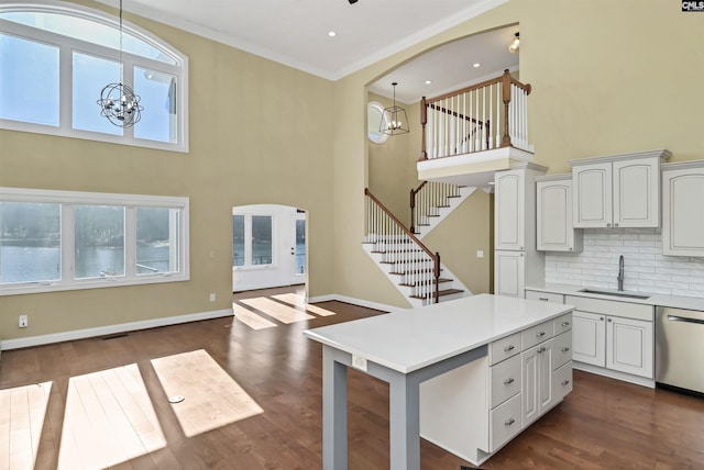 kitchen with dishwasher, sink, white cabinets, and a chandelier