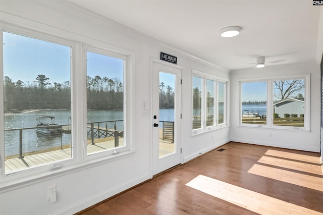 unfurnished sunroom with a water view and ceiling fan