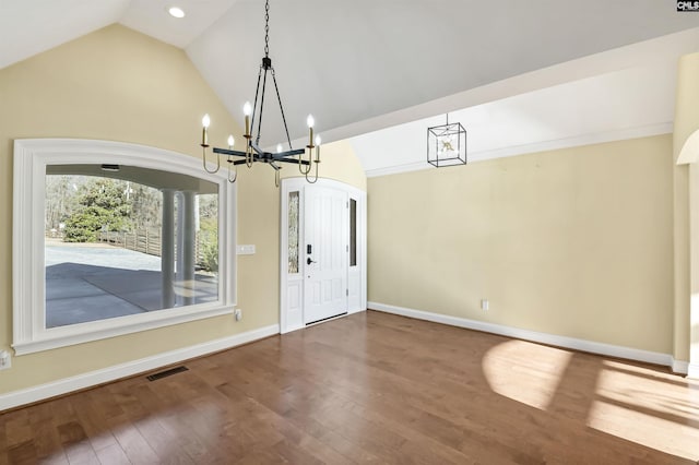 foyer entrance with an inviting chandelier, wood-type flooring, and high vaulted ceiling