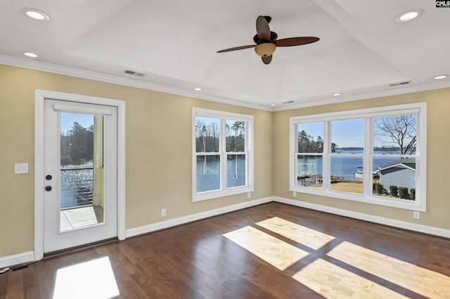 interior space featuring a water view, dark hardwood / wood-style floors, a raised ceiling, and crown molding