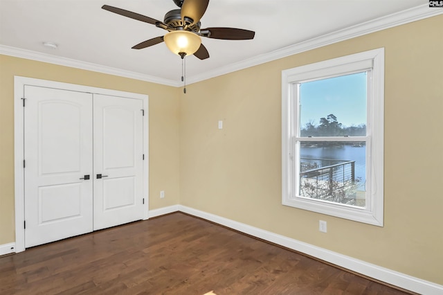 unfurnished bedroom featuring multiple windows, ornamental molding, and dark hardwood / wood-style floors