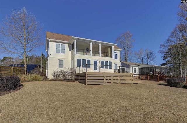 rear view of house with a wooden deck and a sunroom