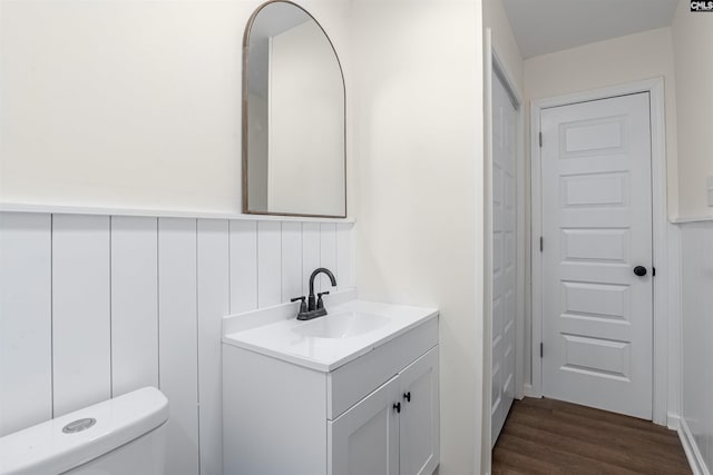 bathroom with hardwood / wood-style flooring, vanity, and toilet