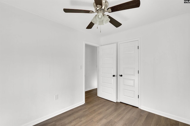 unfurnished bedroom with crown molding, ceiling fan, and dark hardwood / wood-style flooring