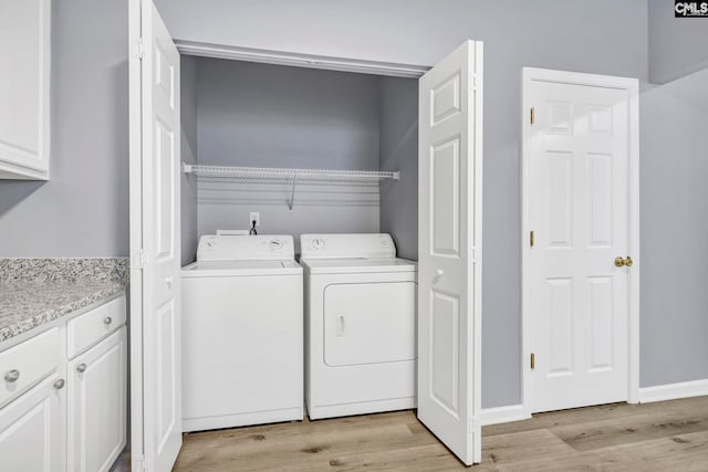 washroom with separate washer and dryer and light hardwood / wood-style flooring