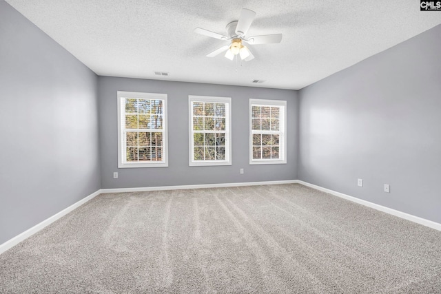 carpeted empty room with ceiling fan and a textured ceiling