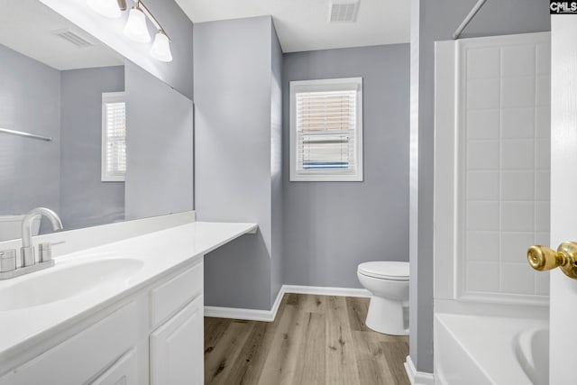 full bathroom featuring vanity, toilet,  shower combination, and hardwood / wood-style floors