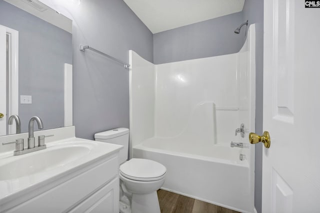 full bathroom with vanity, hardwood / wood-style flooring, bathing tub / shower combination, and toilet