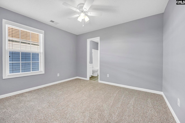 empty room featuring a textured ceiling, ceiling fan, and carpet flooring