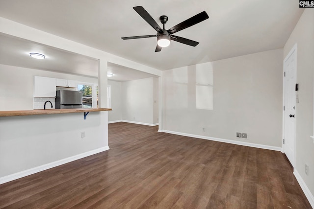 unfurnished living room with ceiling fan and dark hardwood / wood-style flooring