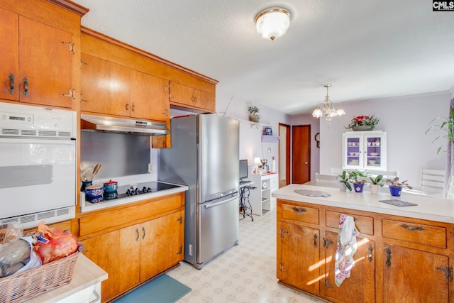 kitchen featuring decorative light fixtures, stainless steel fridge, black electric stovetop, white oven, and an inviting chandelier