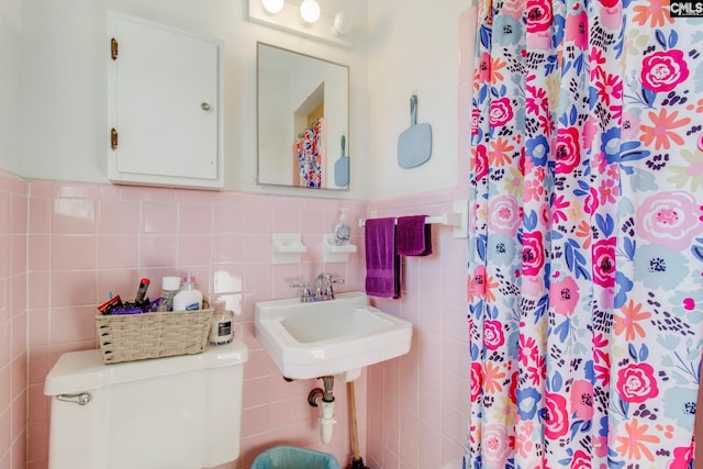 bathroom with a shower with curtain, toilet, sink, and tile walls