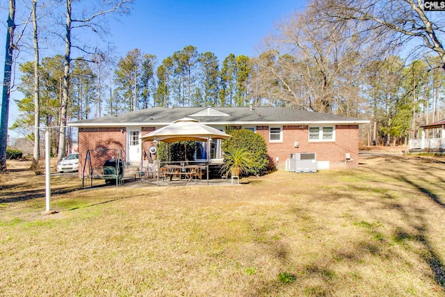 back of property with a gazebo, a yard, central AC, and a patio area