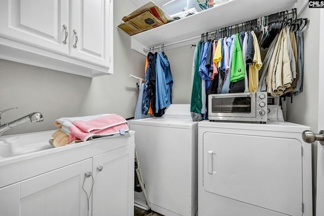 clothes washing area with cabinets, washing machine and clothes dryer, and sink