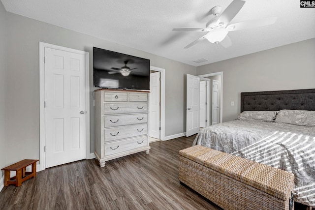 bedroom featuring ceiling fan, dark hardwood / wood-style floors, and a textured ceiling