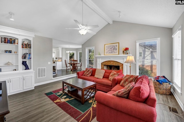 living room with a brick fireplace, a healthy amount of sunlight, and dark hardwood / wood-style flooring