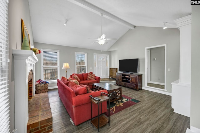 living room featuring dark wood-type flooring, lofted ceiling with beams, ceiling fan, a fireplace, and decorative columns